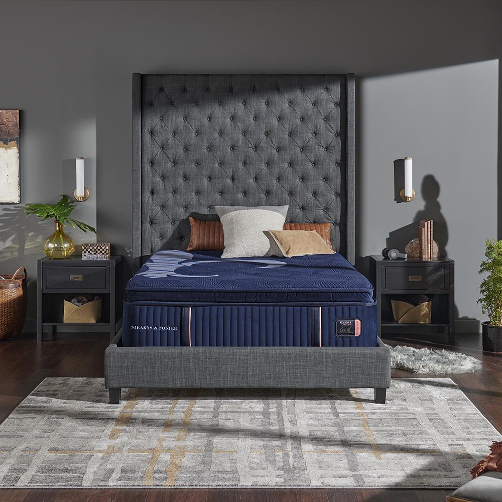 stearns and foster mattress on an upholstered bed frame flanked by two end tables
