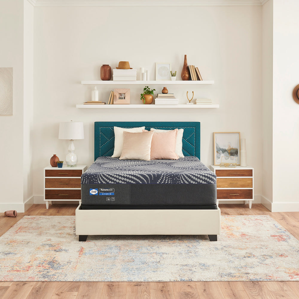 sealy mattress on an upholstered bed frame flanked by two nightstands