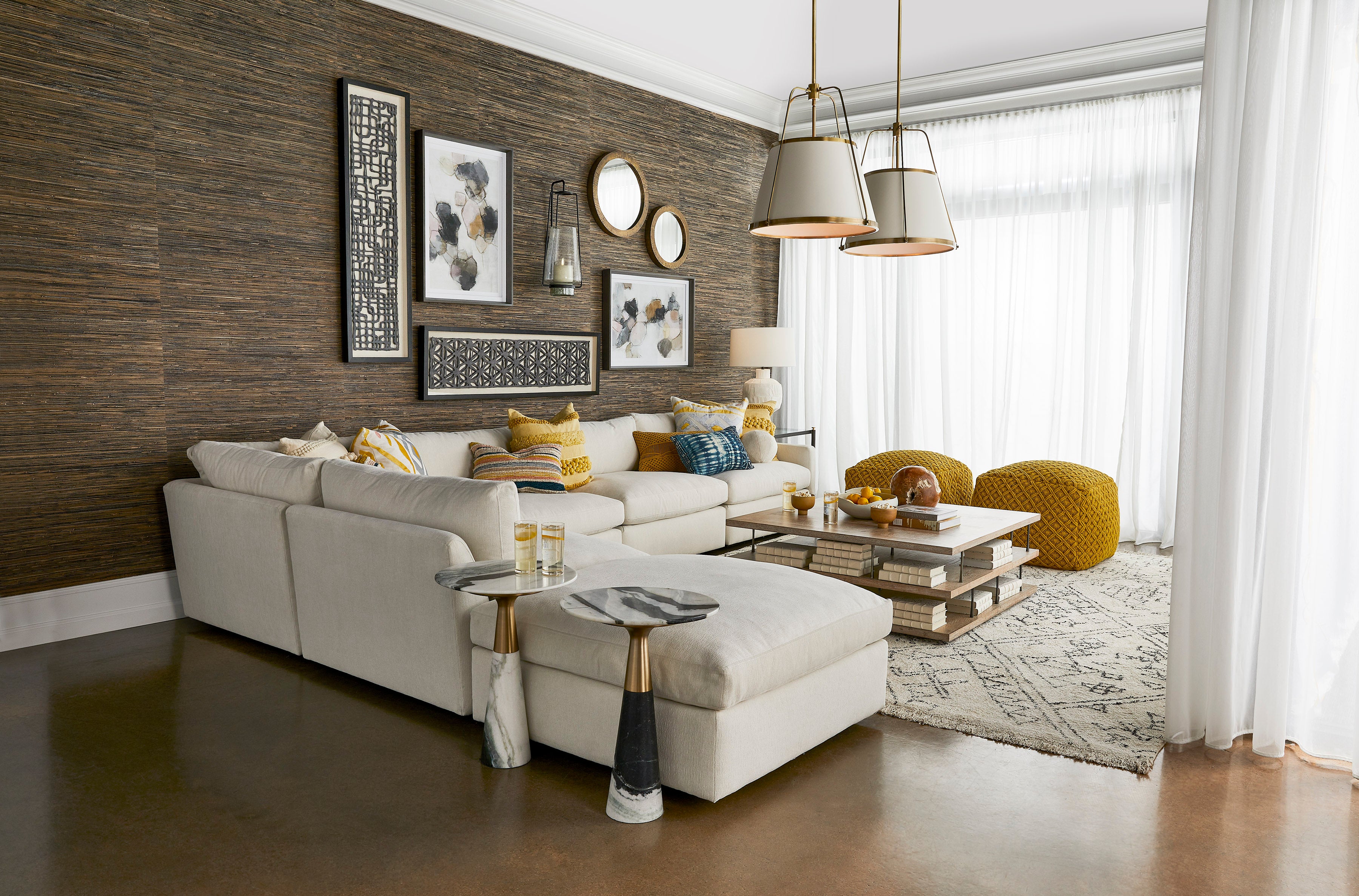 A large white sectional in a modern living room with brightly colored accent pillows.