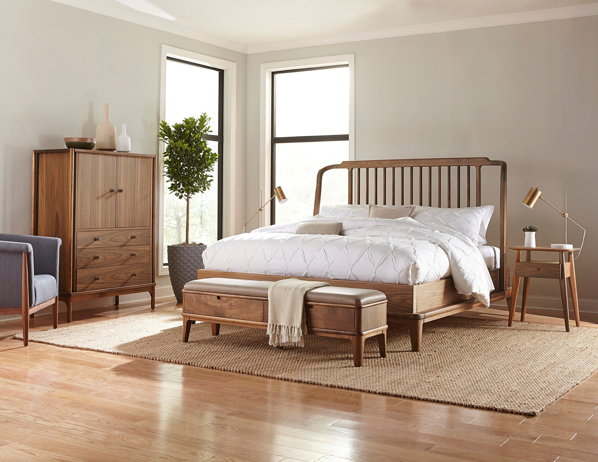 Stickley Walnut Grove collection bedroom scene featuring a wood spindle bed, storage bench, matching nightstand, and matching wood gentleman's chest.