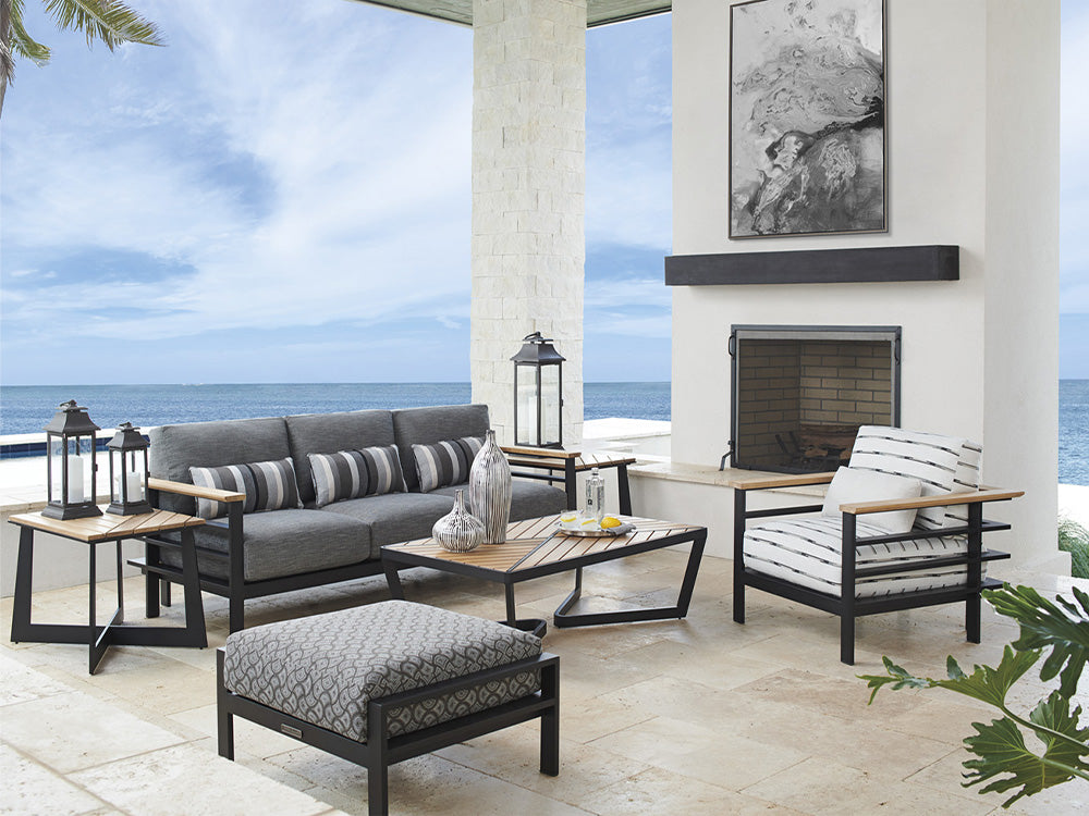 An outdoor patio with a sofa, tables, and a chair from Tommy Bahama Outdoor.