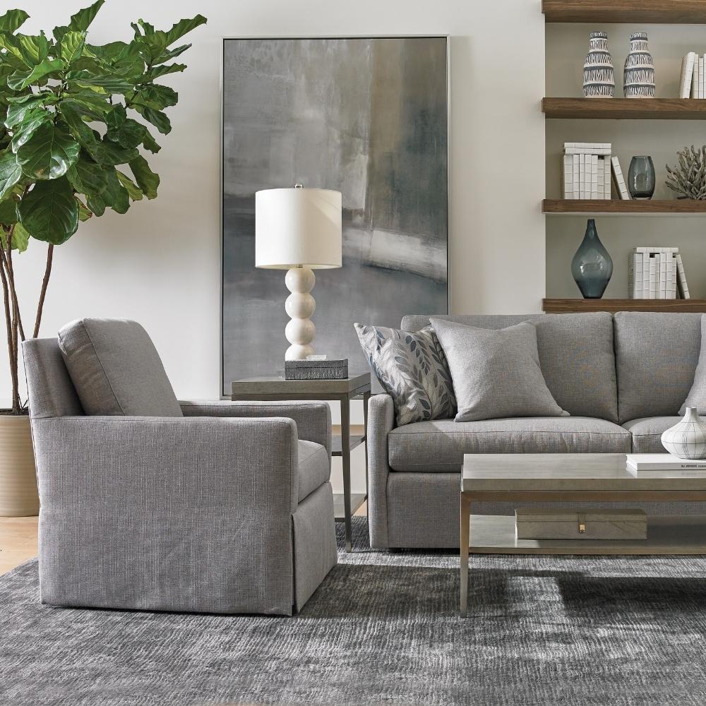 living room scene with grey sofa, matching grey arm chair, and metal coffee table.