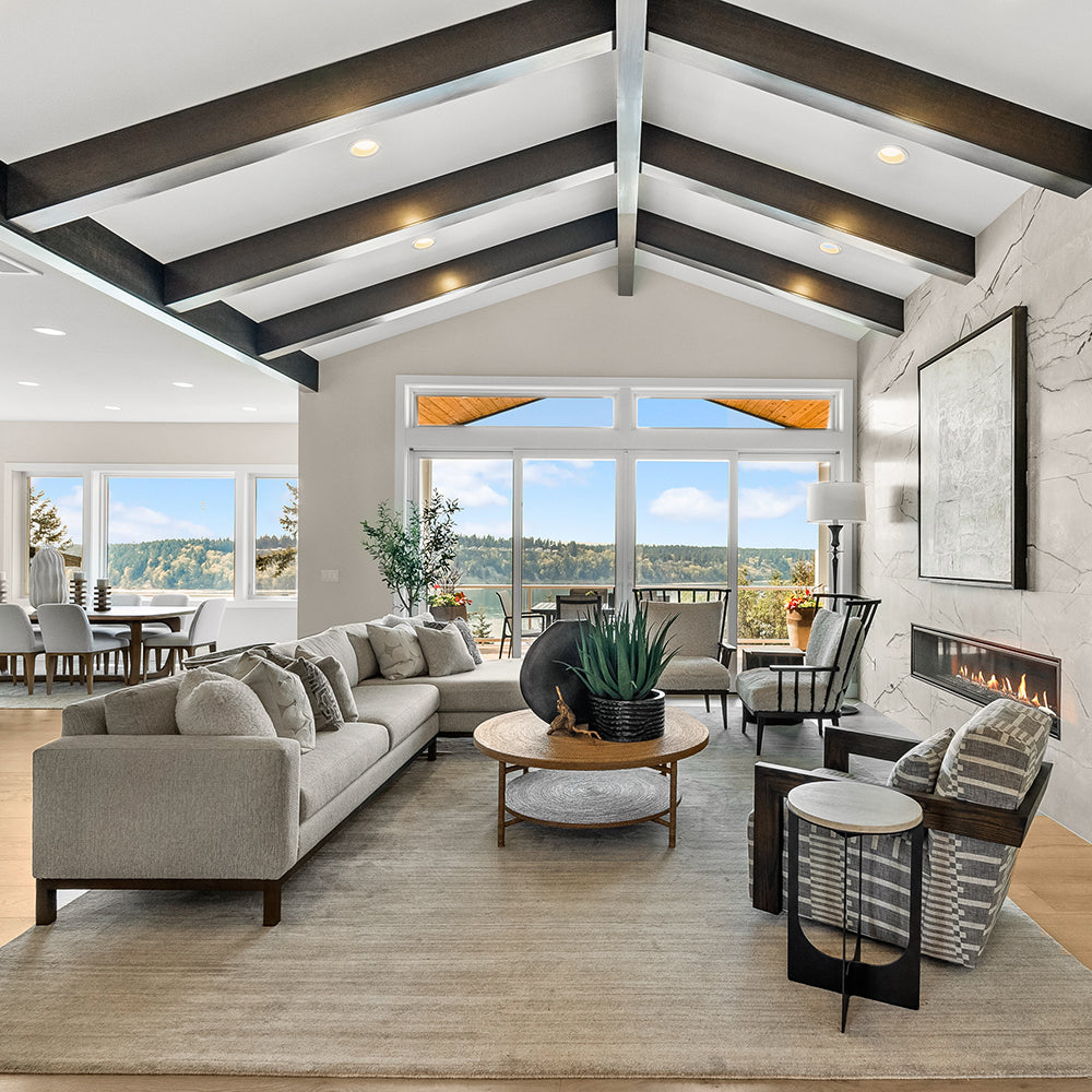 large open living room area with sectional sofa, coffee table, and three chairs in front of sliding glass doors