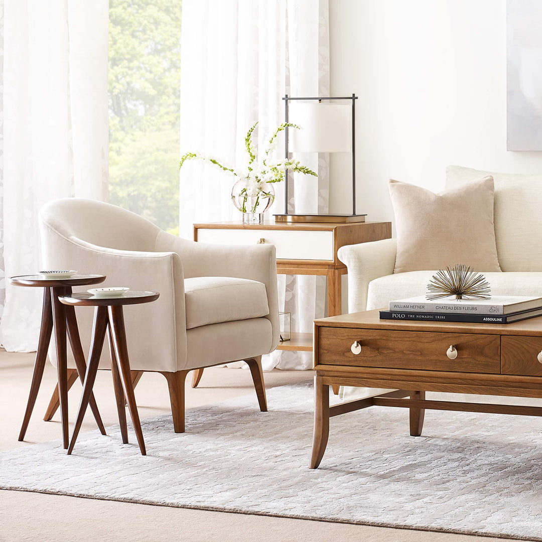 White fabric arm chair with two small wood accent tables in front of a medium-finished wood coffee table from Stickley's Martine Collection.