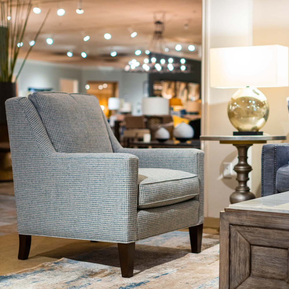 blue arm chair next to round side table with showroom in background