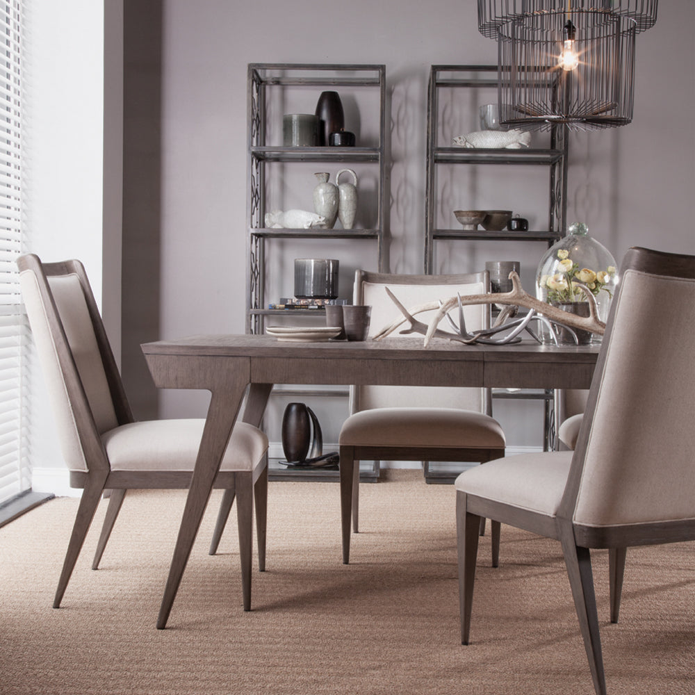 Modern dining room with gray-washed wood table surrounded by matching upholstered chairs.