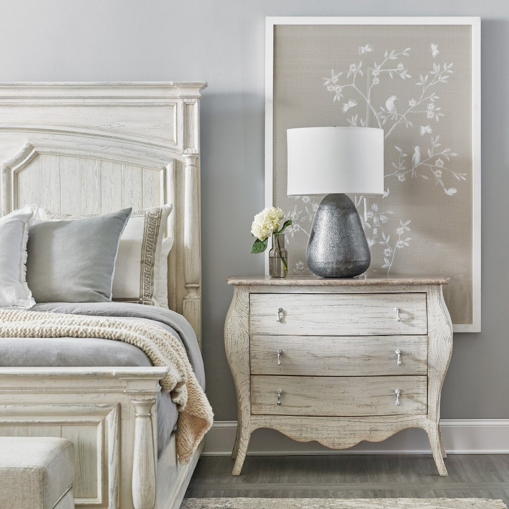 white wood cabriole style nightstand next to matching white wood bed
