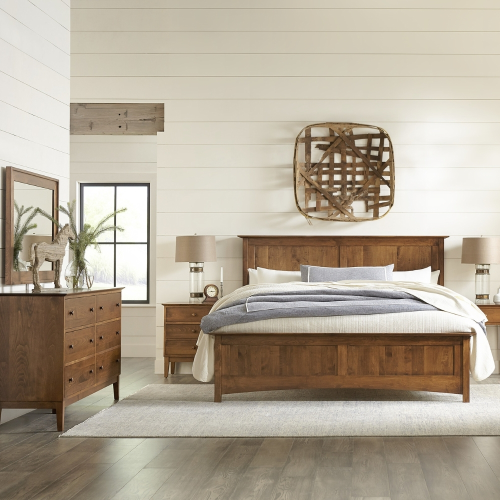 stickley gable road bedroom scene with warm brown wood bed, nightstands, dresser, and mirror