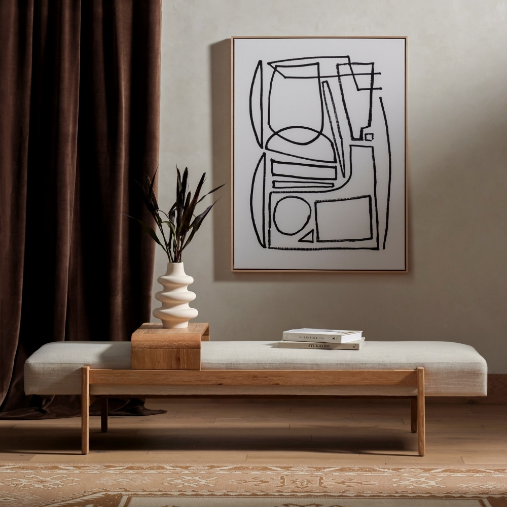 modern wood and fabric bench in front of long brown curtains and abstract wall art.