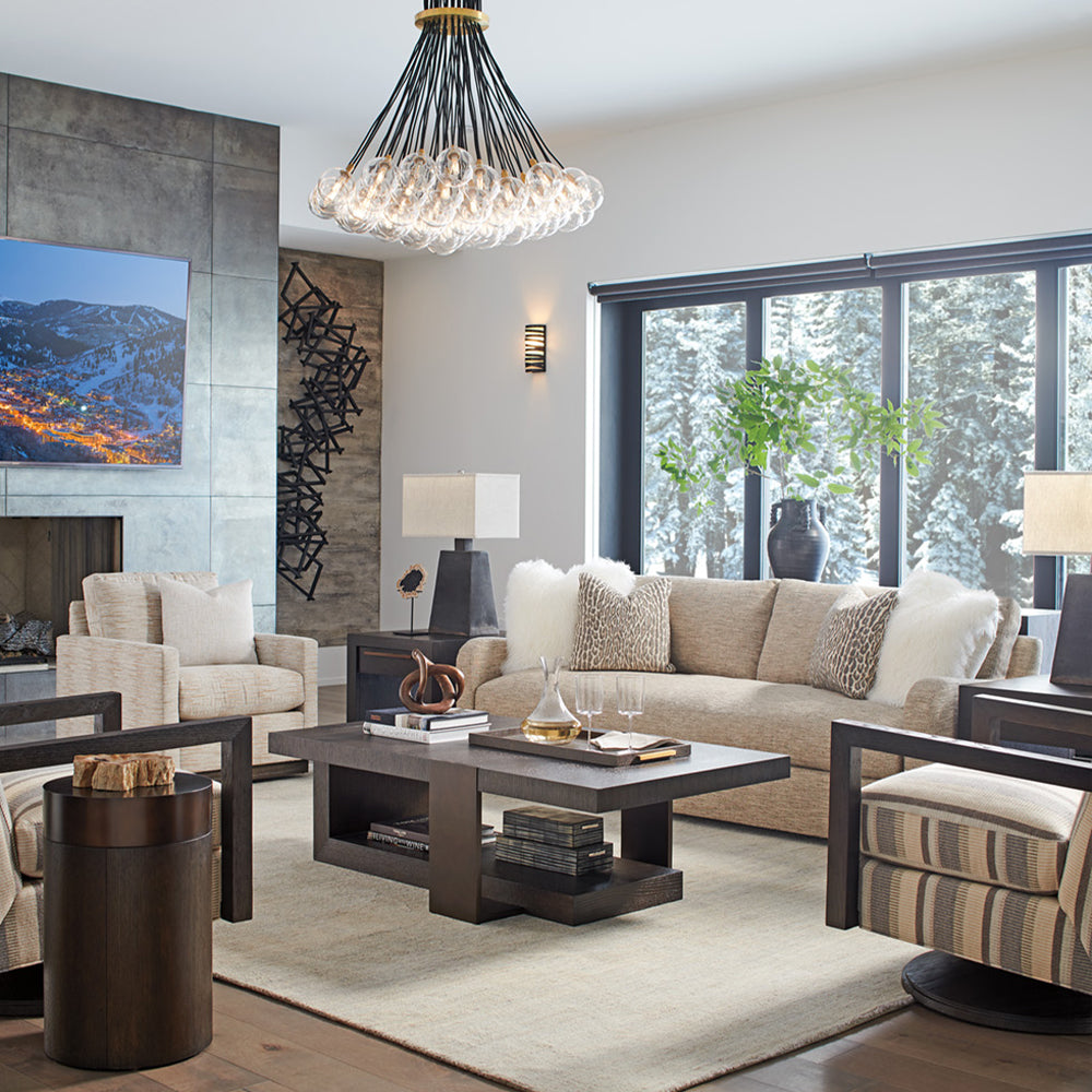 living room scene with a beige sofa and a dark wood coffee table and three arm chairs