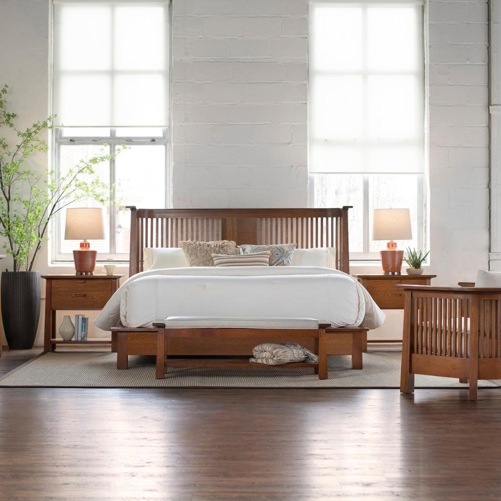 large bedroom scene with wood bed, matching nightstands on either side.