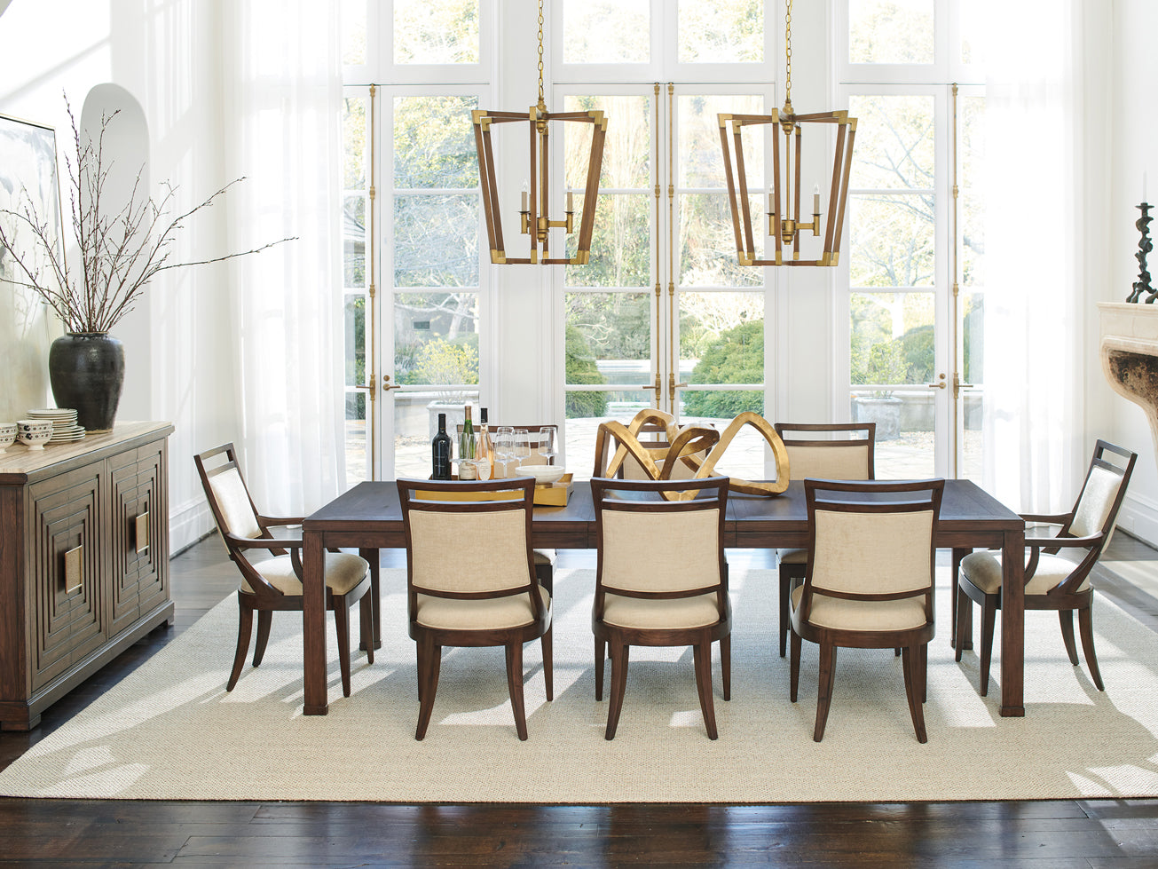 A large dark wood dining table surrounded by matching fabric and wood dining chairs.