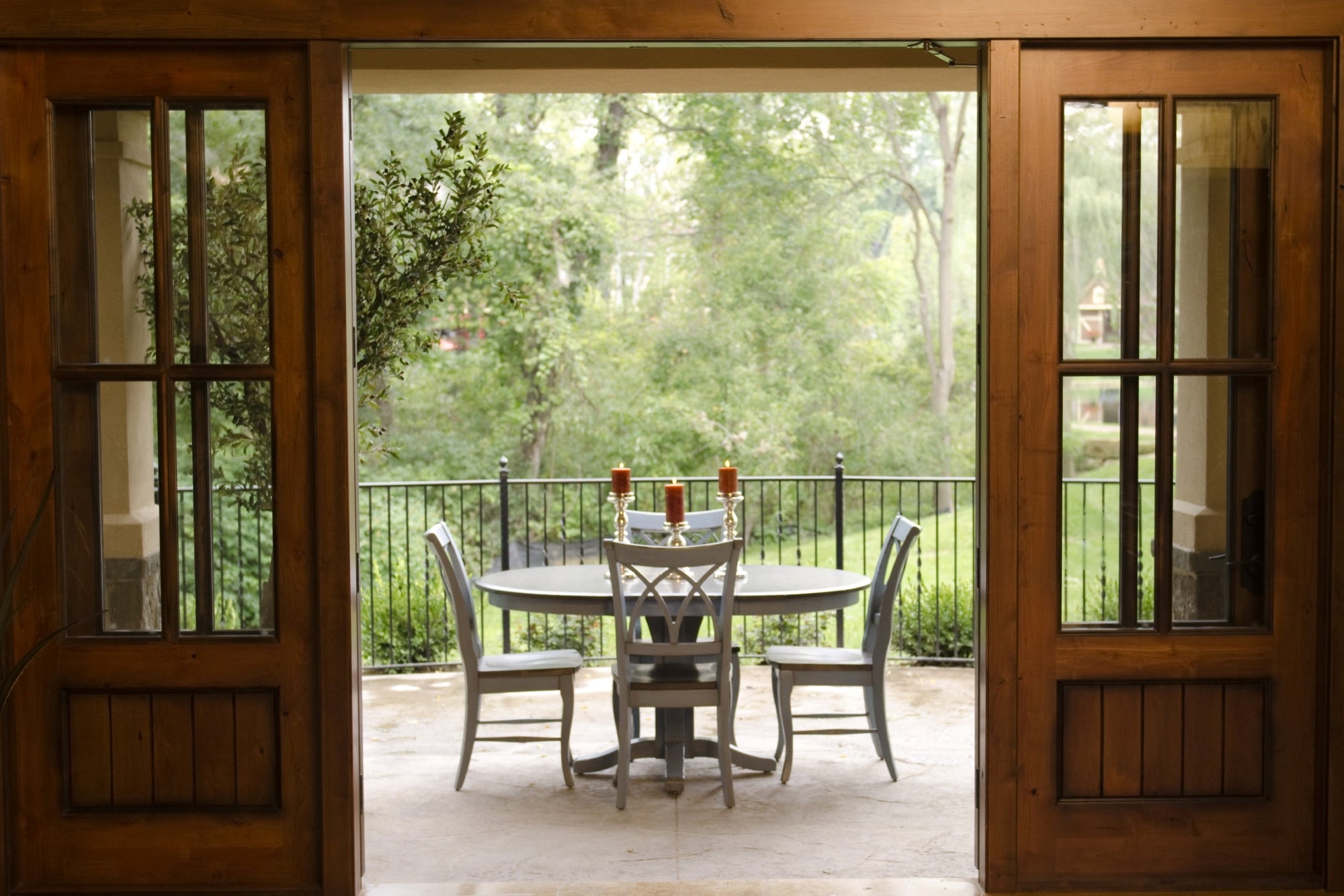 Small oval dining table on an outdoor patio with four matching dining chairs