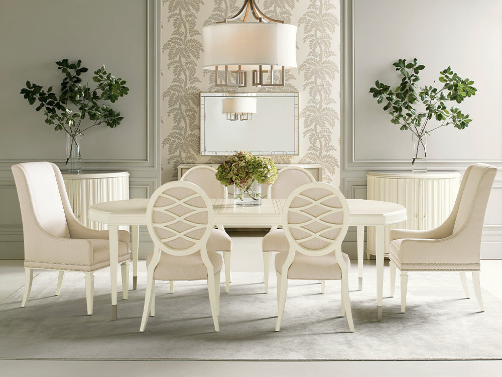 A brightly lit dining room scene from Caracole featuring an off-white dining table with matching dining chairs.