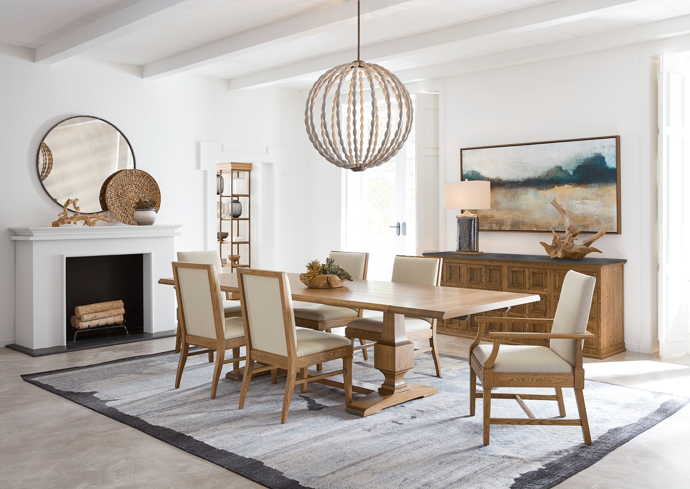 Dining room scene from Stickley's St. Lawrence collection featuring a large light wood dining table surrounded by matching fabric and wood dining chairs.