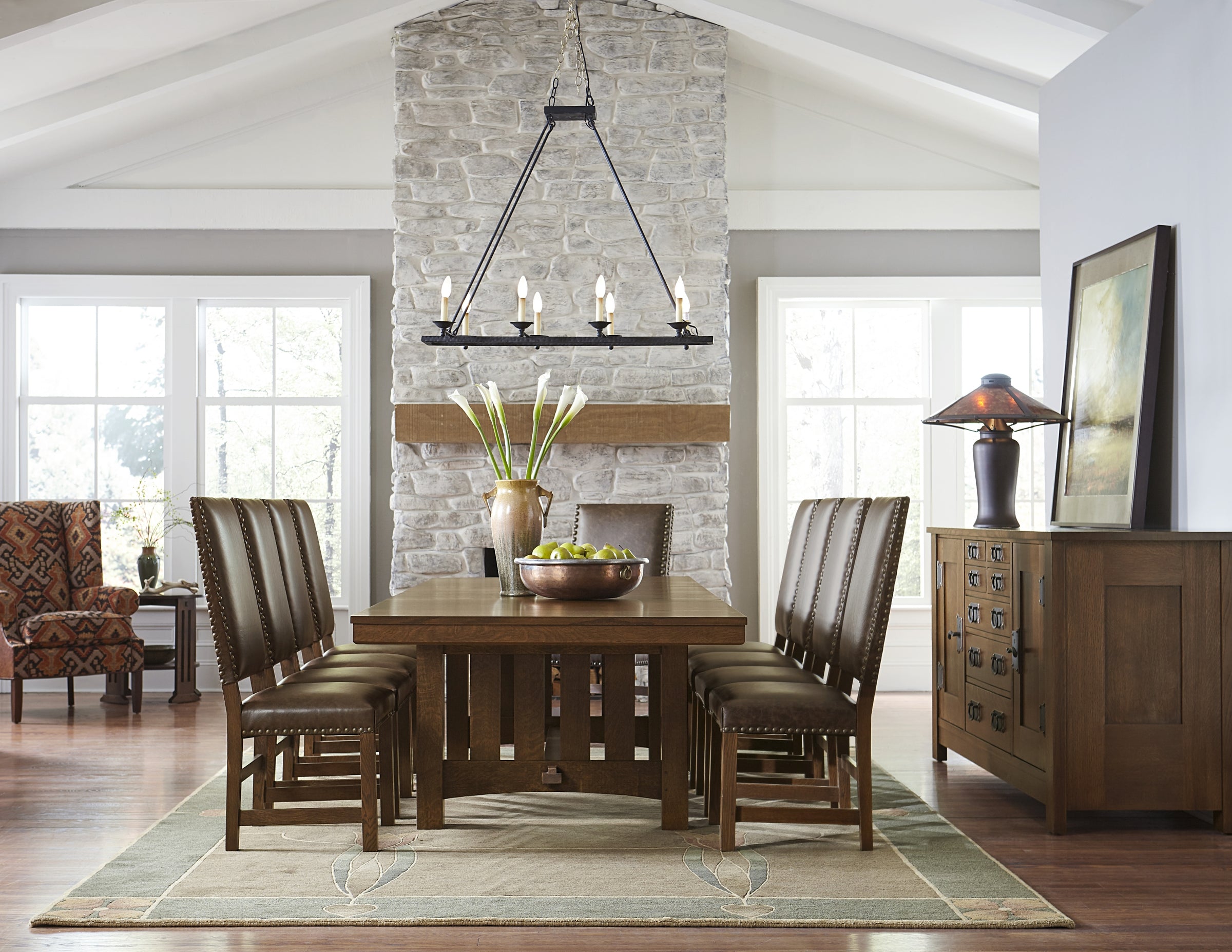 Rustic dining room scene from Stickley featuring a large wood dining table surrounded by leather and wood dining chairs.