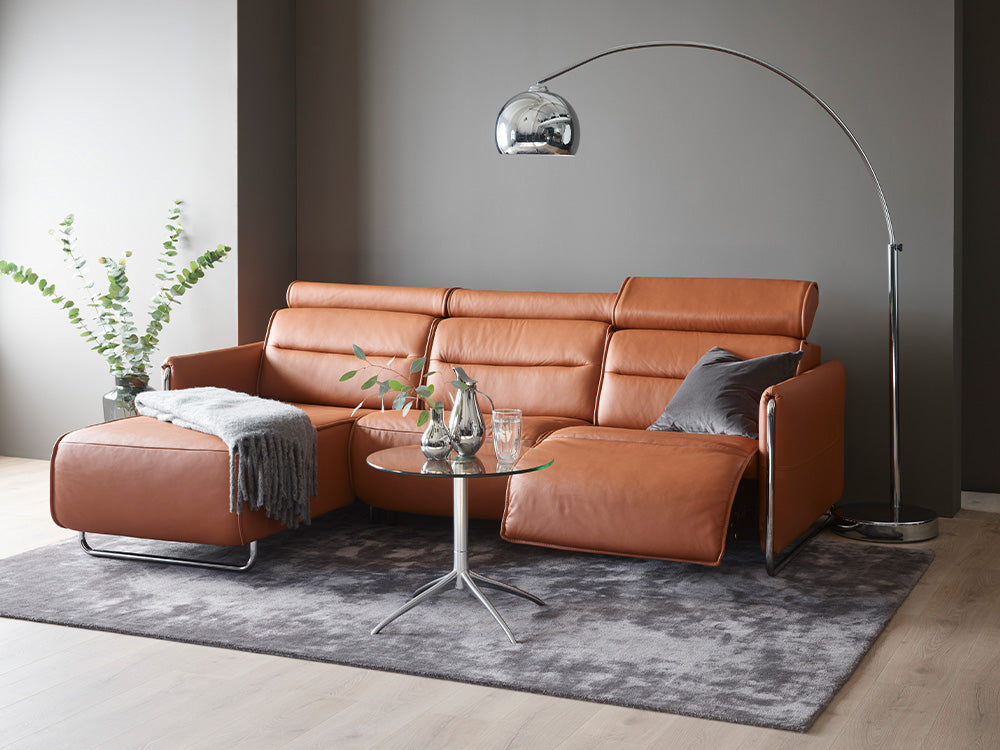 An orange leather reclining sofa from Stressless by Ekornes.