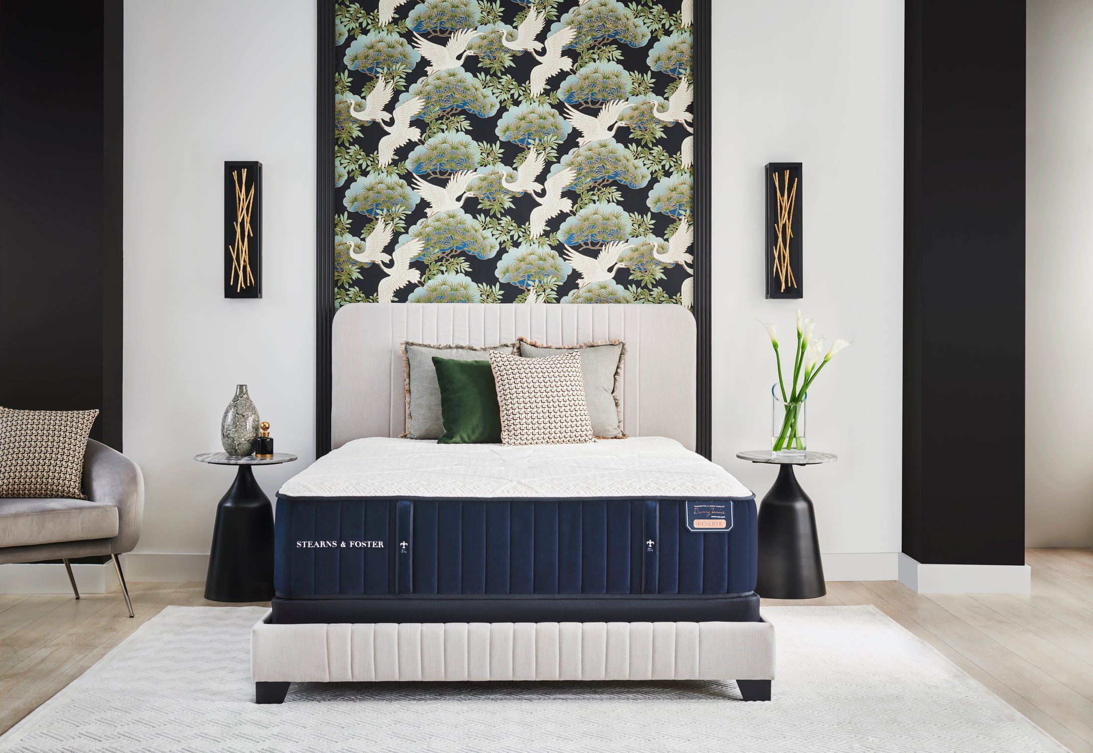 A stearns and foster mattress sits on a white upholstered bedframe in a minimalist modern style bedroom.