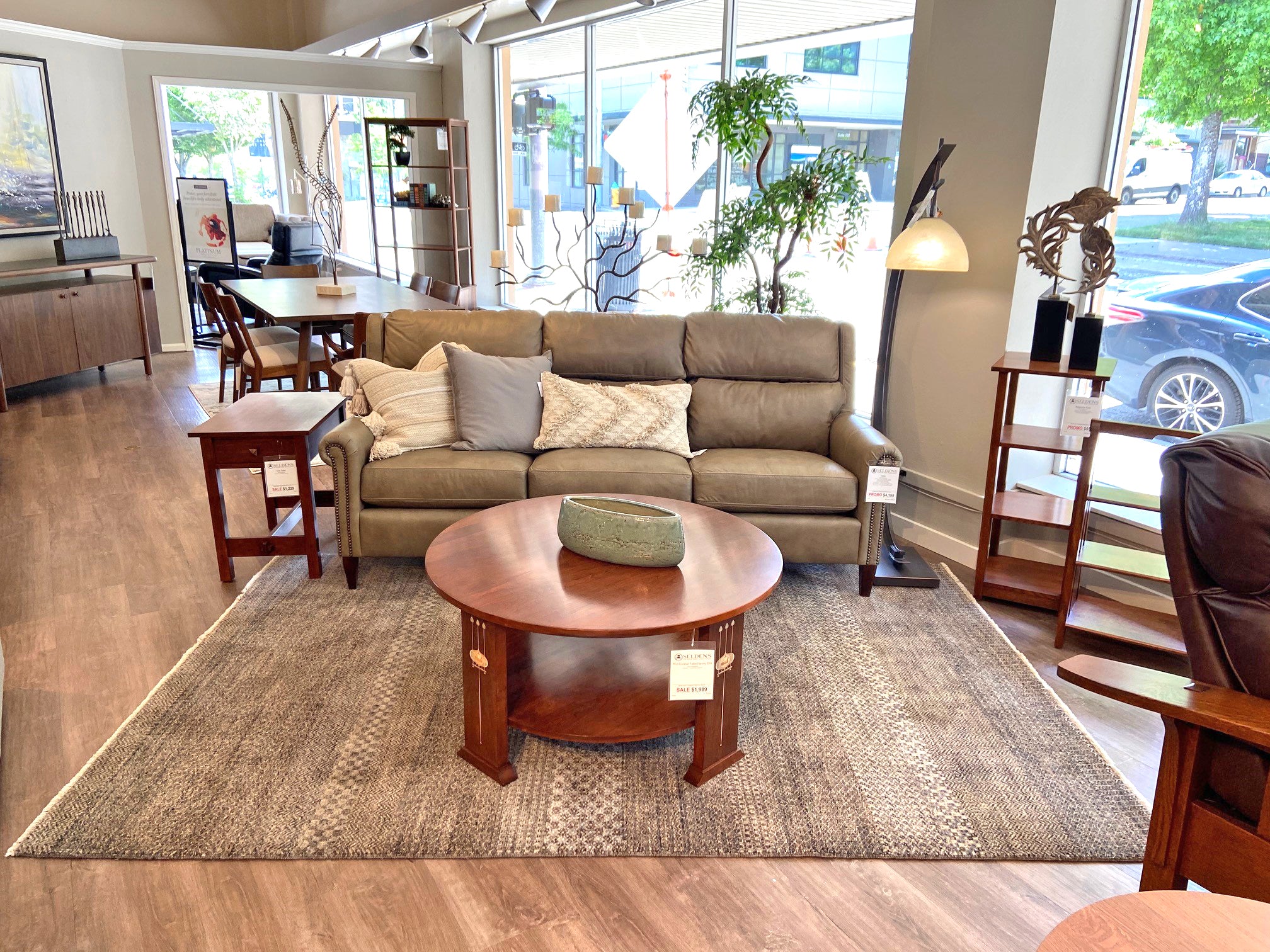 A tan leather sofa with a wood cocktail and end table inside the Seldens furniture showroom in Olympia, Washington.