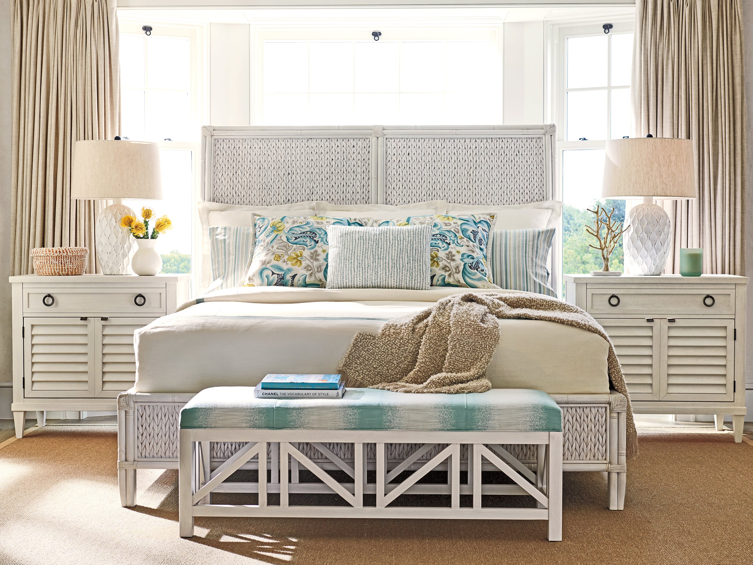 A coastal style bedroom from Tommy Bahama Home's Ocean Breeze collection featuring a white bed with matching nightstands.