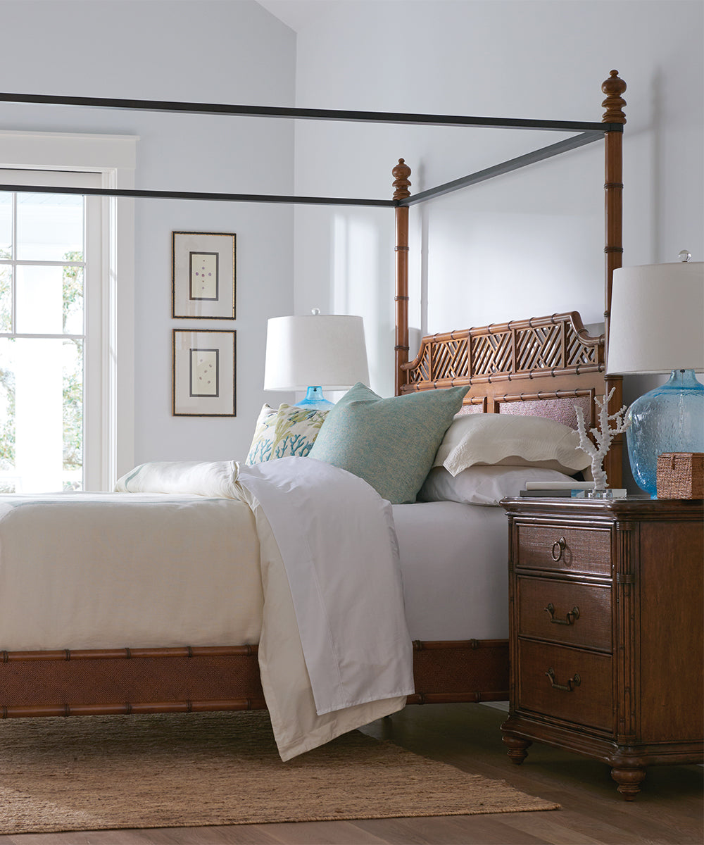 A large wood canopy bed with matching nightstand.