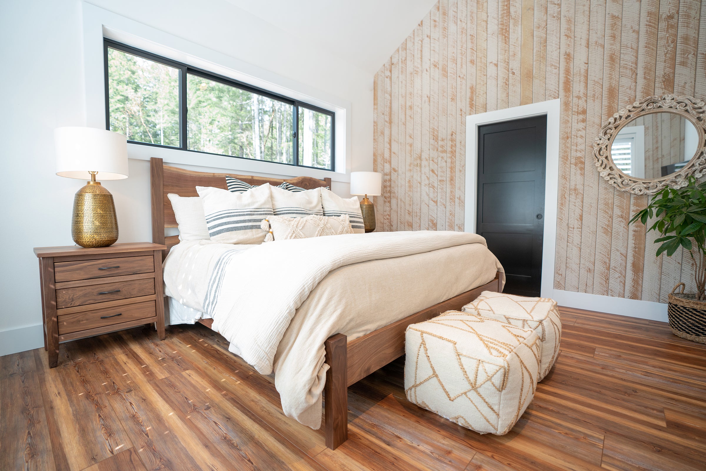 Casual, rustic bedroom scene with a large wood bed and matching nightstand.