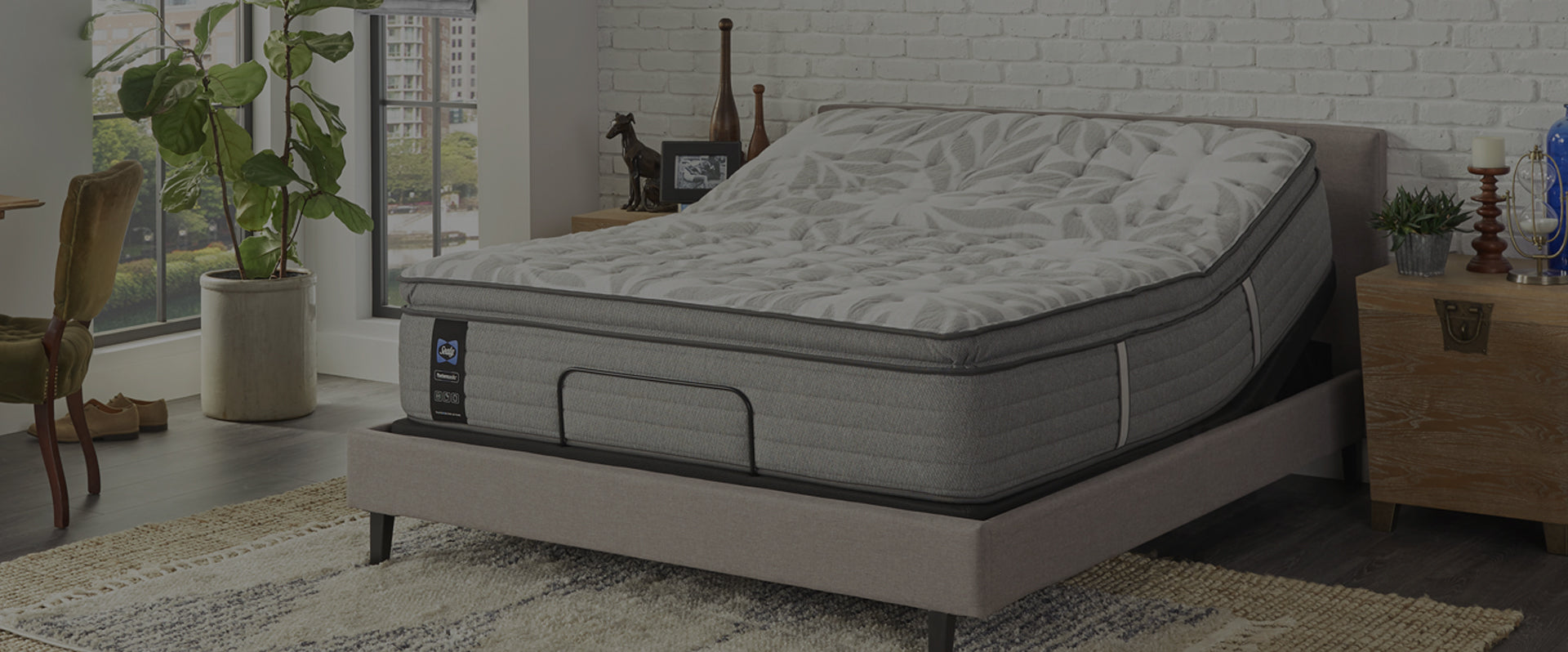 gray Sealy mattress on an adjustable base in a bedroom scene