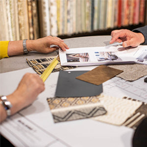 Fabric samples and room plans are laid out on a small table.