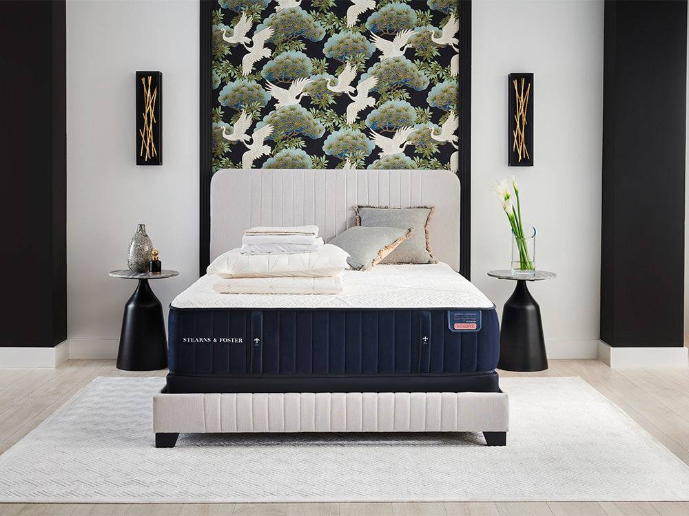 A Stearns and Foster mattress on a white upholstered bedframe in a modern bedroom setting.